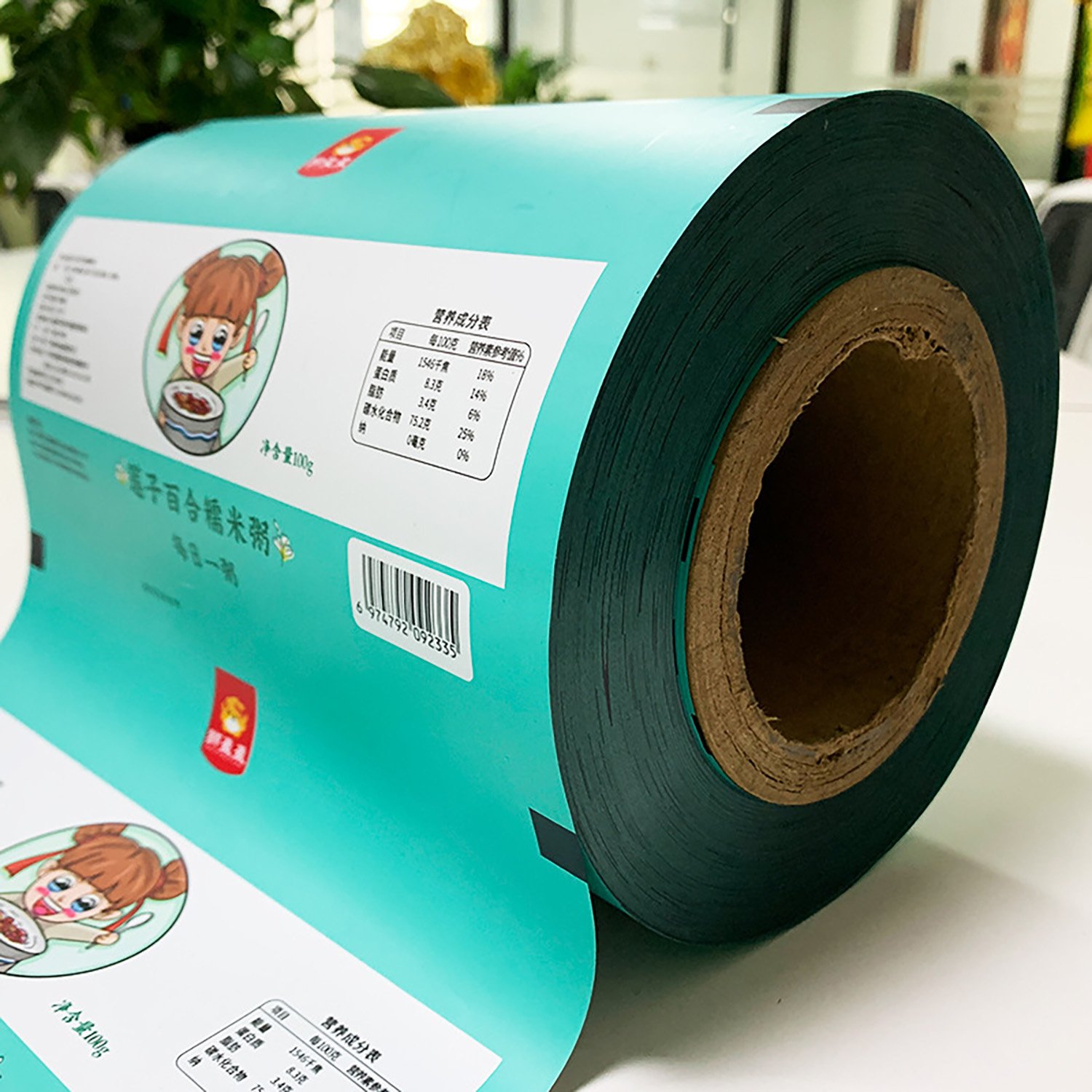 Close-up photo of custom-printed flexible film wound around a roll core, with sample artwork visible.